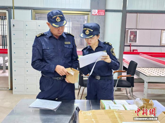  海关关员在磨憨国际快件物流中心对进境快件进行监管。赶四 摄