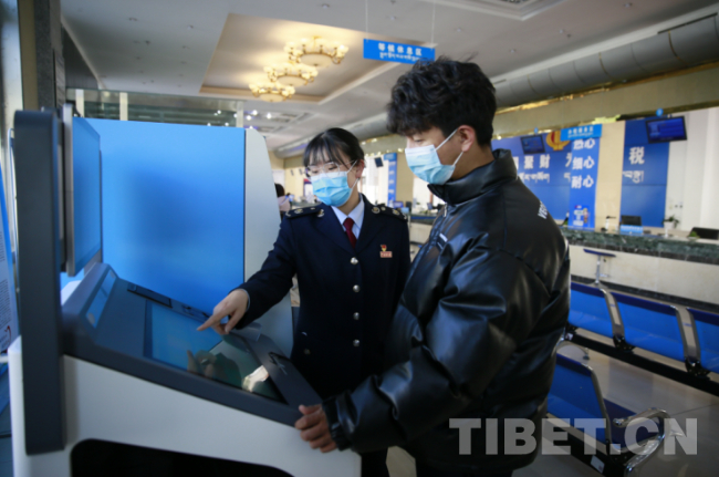 图为税务干部帮助纳税人线上便捷办税　图片来源：国家税务总局西藏自治区税务局