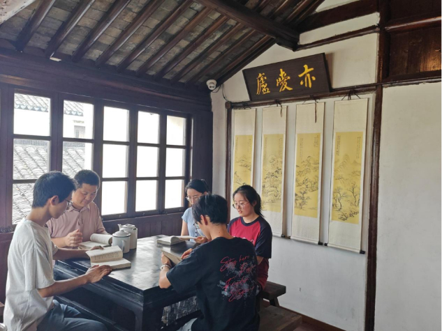 图为实践团成员与老师讨论红色通信历史