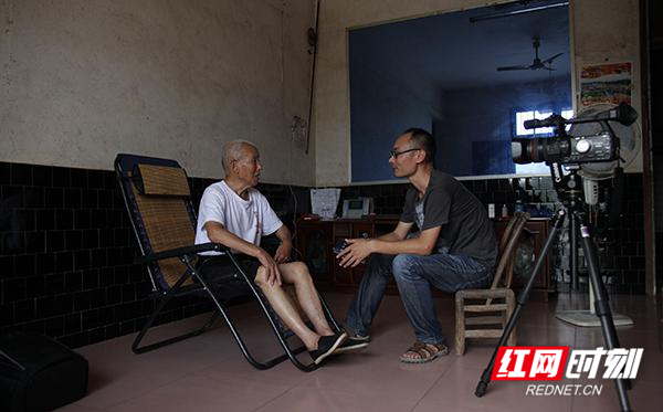 2014年7月9日，在浏阳市镇头镇土桥村，马金辉（右）走访抗战老兵陈香岑。