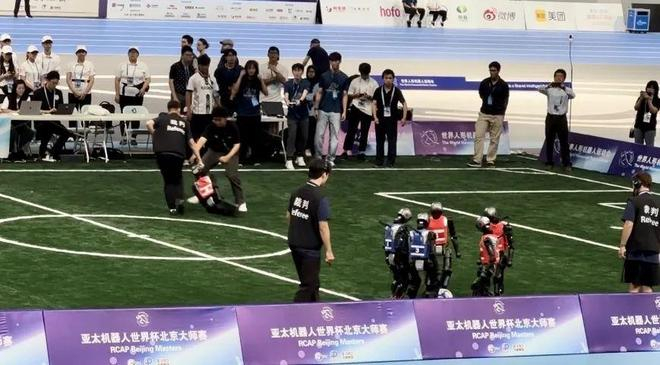 扎堆研究球的机器人和它们负伤被拖走的队友，图源：作者拍摄