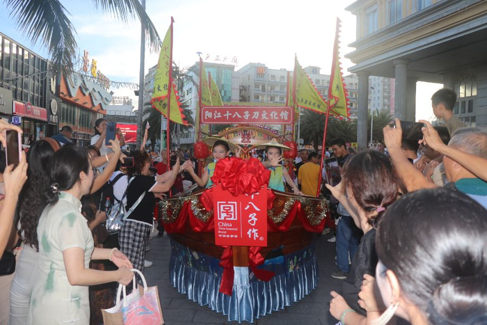 （渔家大宴现场，阳江十八子刀文化馆主题巡游，吸引众人围观。张梦琦/摄）