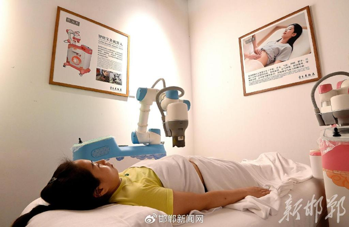 在邯郸道上的太极养生堂，游客在体验智能艾灸机器人。