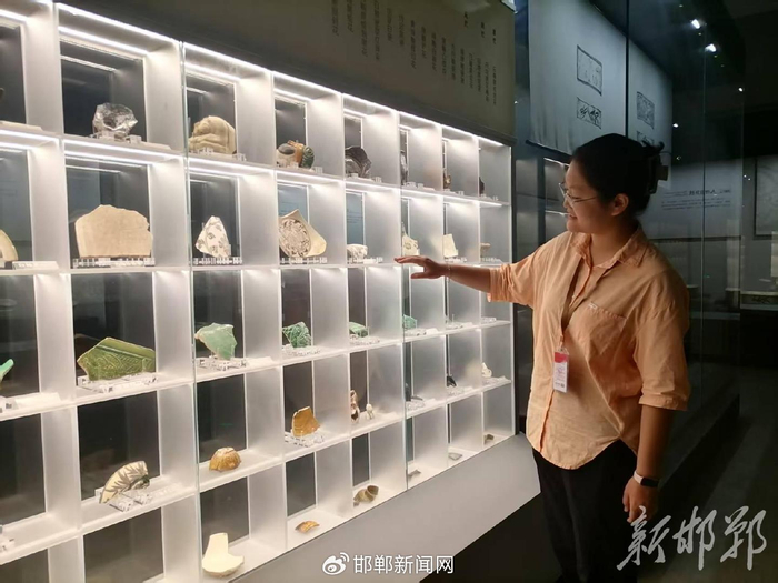 保定学院文物与博物馆学专业大三学生刘馨泽站在展柜旁为游客讲解。邯郸新闻传媒中心记者 牛冰洁摄