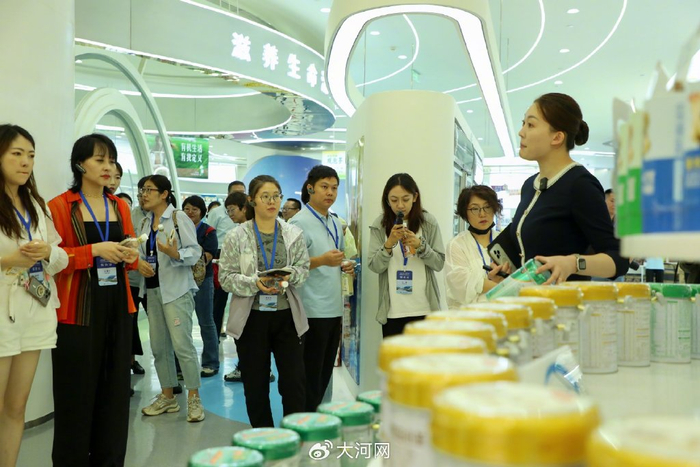 讲解人员向媒体团成员介绍伊利产品。郭成 摄