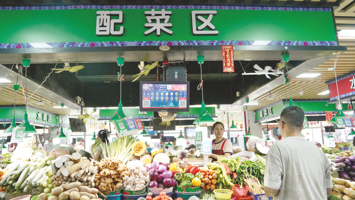 友谊智慧农贸市场内，配菜区档口上方悬挂着显示屏，详细展示档口信息。记者 蓝梦 摄