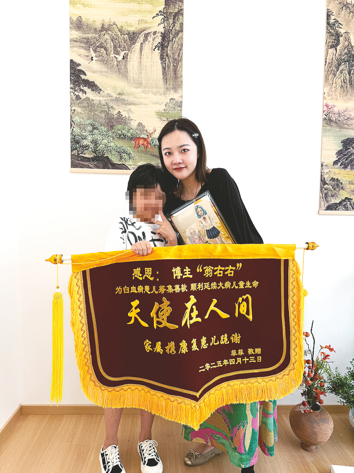     菲菲给翁忻怡（右）送锦旗。    （受访者供图）