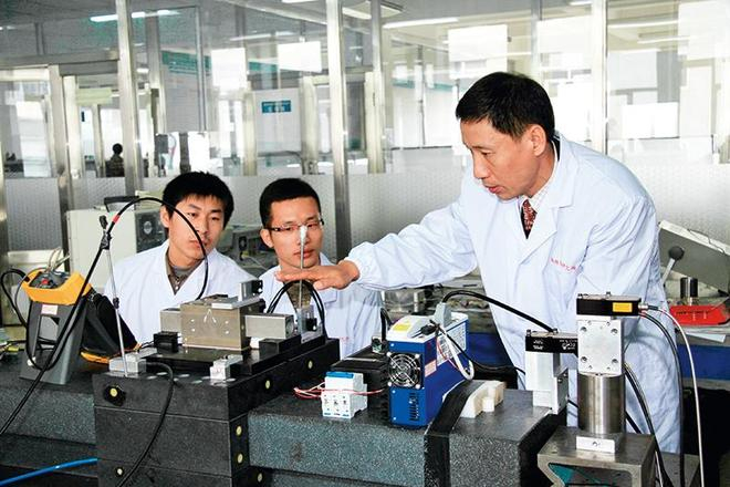 在哈尔滨工业大学超精密光电仪器工程研究所，谭久彬院士（右）指导学生进行实验（资料照片） 哈工大仪器学院供图