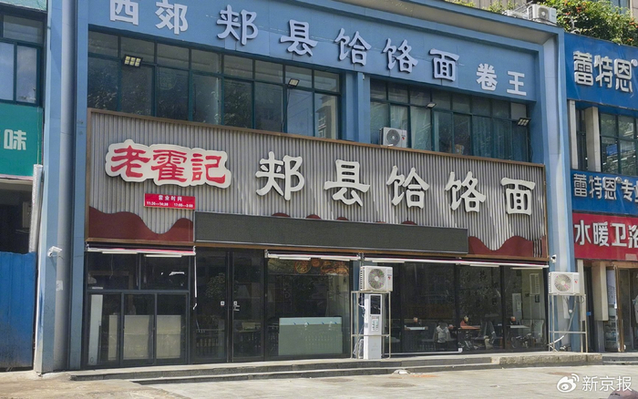 19日中午，郑州“续面事件”门店闭门落锁，店外多名辖区办事处工作人员对拍摄、围观人员劝离。 新京报记者 程亚龙 摄