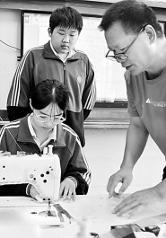 湖南省永州市江永县职业学校的老师在指导学生进行服装裁缝实践操作。田如瑞摄/光明图片