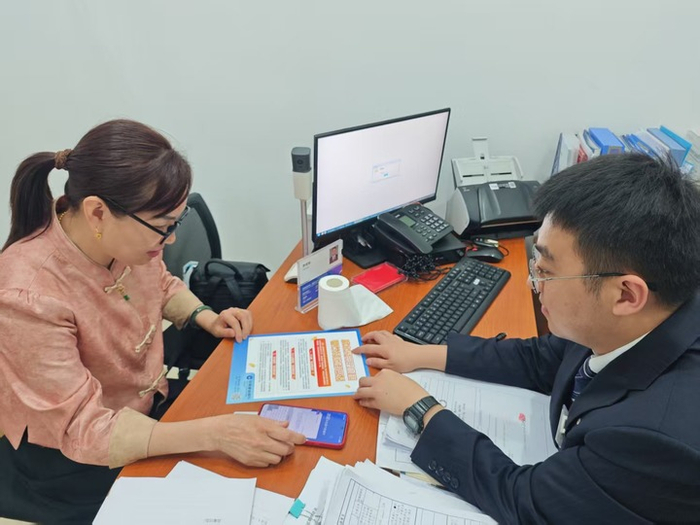 建设银行宜宾市分行工作人员向客户介绍明示企业贷款综合融资成本试点工作。（刘志鑫 摄）