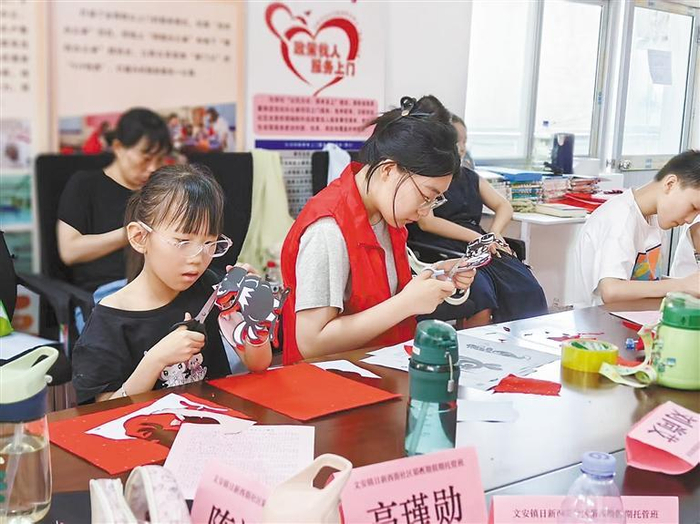     图为孩子们在托管班学习剪纸。    本报记者 张甜歌 摄