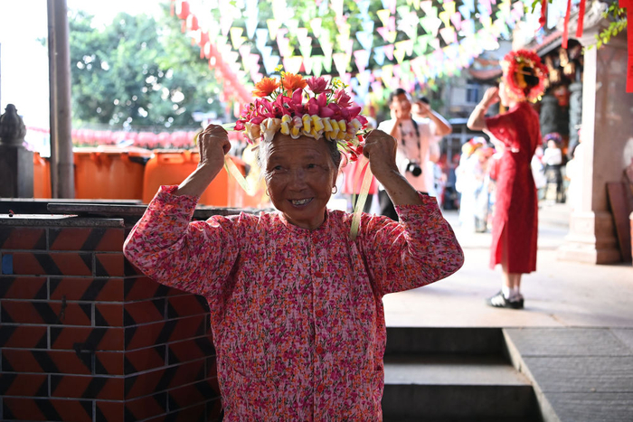 　　8月18日，福建泉州蟳埔村，一名卖鲜花花围的蟳埔女在做展示。