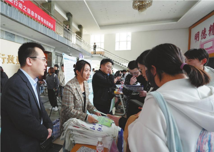         招才引智专班工作人员向应聘学生讲解人才政策。