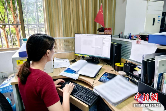 图为黄小芳在办公室撰写材料。 受访者供图