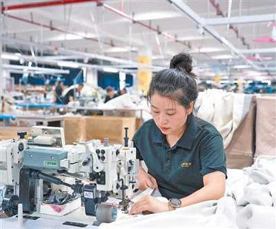 　　图为刘线在缝制窗帘。