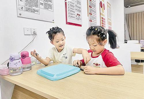     8月8日，在石家庄市新华区明珠花苑社区公益托管班，两位小朋友正在玩游戏。本报记者 贾梦宇摄