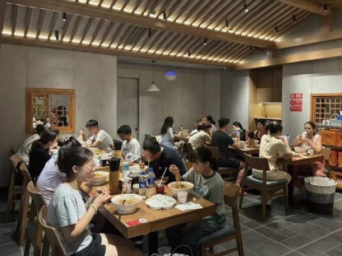 　　图为消费者在方砖厂69号炸酱面门店内就餐。