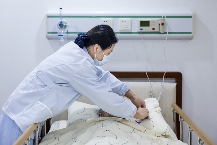 資料：護理員陳俊在安寧療護室內為老人進(jìn)行護理