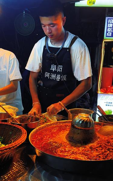 　　龚亚洲在杭州摆摊卖阜阳卷馍。（视频截图）     