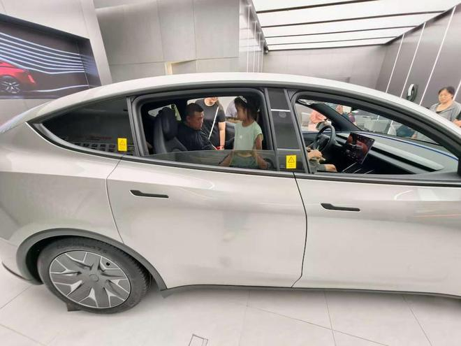 ▲特斯拉门店内顾客带娃来体验新车