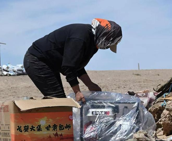▲在河西走廊的牧区，当地牧民正拆开从拼多多上网购回来的发电机。（陈蕾 摄）