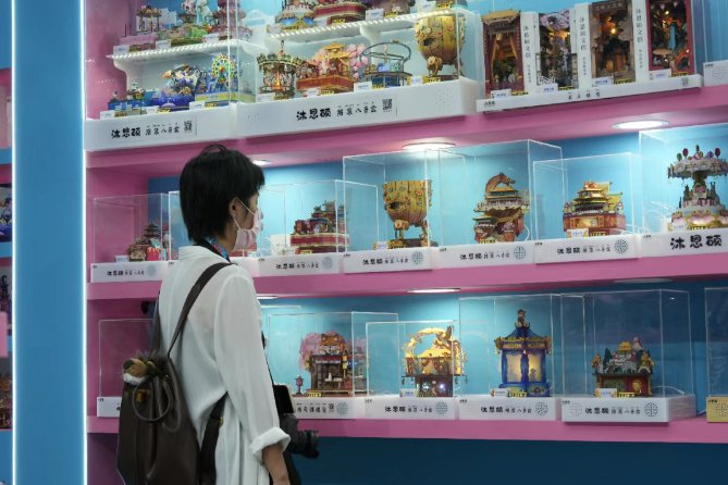 　　图为观众被带有中国传统特色元素的木制拼装八音盒吸引。唐 瑞 摄