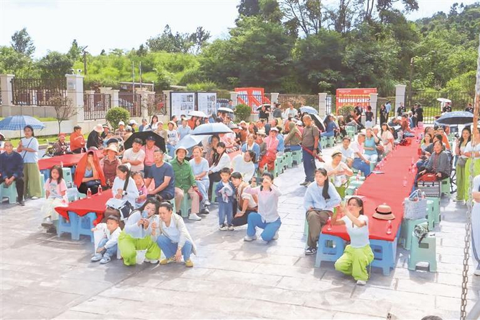 安顺经开区誉景三合小区内，旅居新市民在长桌宴活动前观看文艺演出。 （采访对象供图）