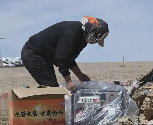 ▲在河西走廊的牧区，当地牧民正拆开从拼多多上网购回来的发电机。图源/受访者