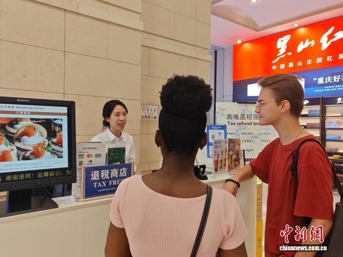 图为在重庆解放碑的重庆环球金融中心离境退税服务台，工作人员为境外游客介绍离境退税“即买即退”服务。徐佑君 摄