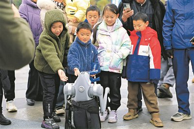 ◀孩子们与机械狗互动。     黄伟 摄