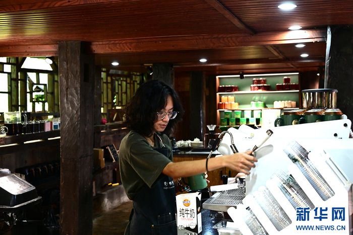 在野鸭塘河谷·景迈山店，工作人员正在冲泡咖啡（8月26日摄）。新华网发（刘起 摄）
