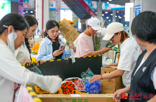 8月28日下午，斗南花市内的快递服务站，市民正在等待工作人员包装鲜花。人民网记者 虎遵会摄