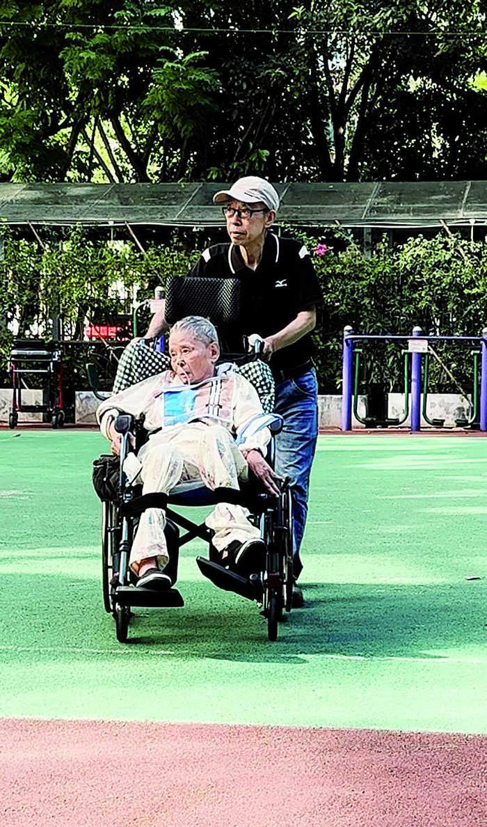     李茂泉推着妻子散步