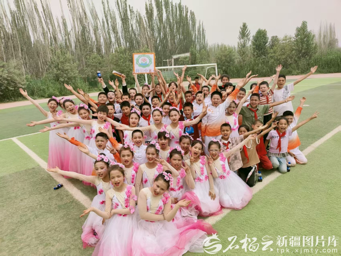 和田县布扎克乡第一中心小学学生参加校园文化艺术节表演后合影留念。（资料图）