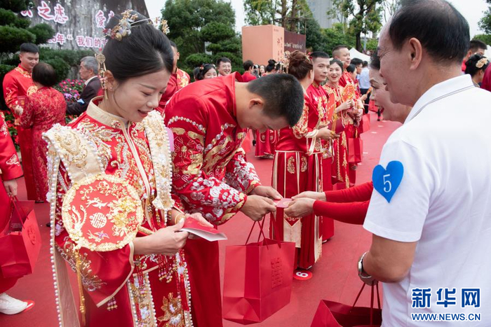 银婚夫妇为新人颁发结婚证书（8月29日摄）。新华网发（供图）