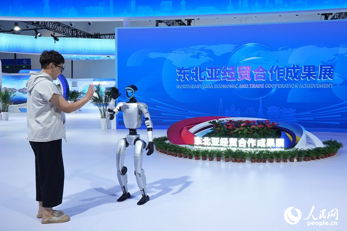 游客在東北亞經(jīng)貿合作成果展上與機器人握手。人民網(wǎng)記者 李洋攝