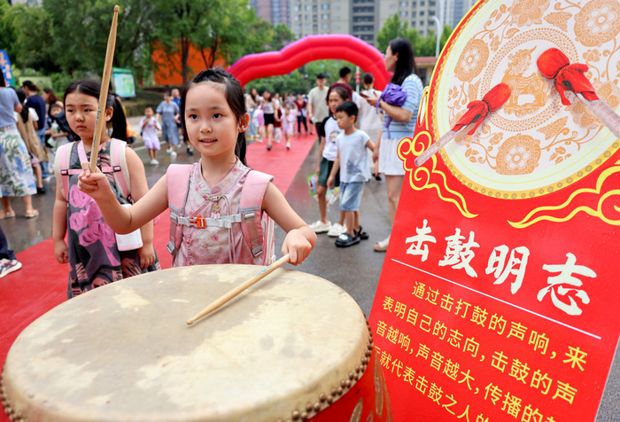 8月30日，在山东省枣庄市市中区东湖小学，一名一年级新生在“击鼓明志”。新华社发（孙中喆 摄）