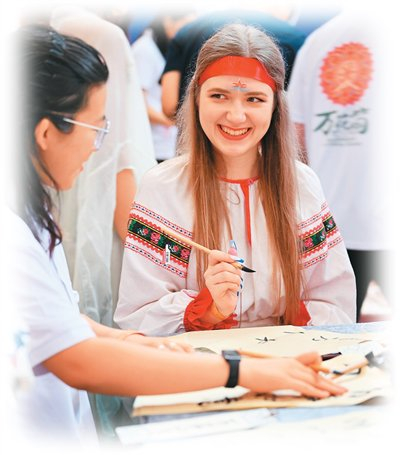 8月6日，“上合之约·丝路津彩”上合国家青年学生“万花筒”文化市集在天津举行。图为青年学生体验书法。新华社记者 李 然摄