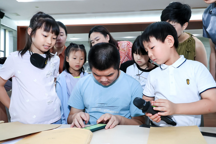 图2 视障学生向少年发起人演示盲文的书写