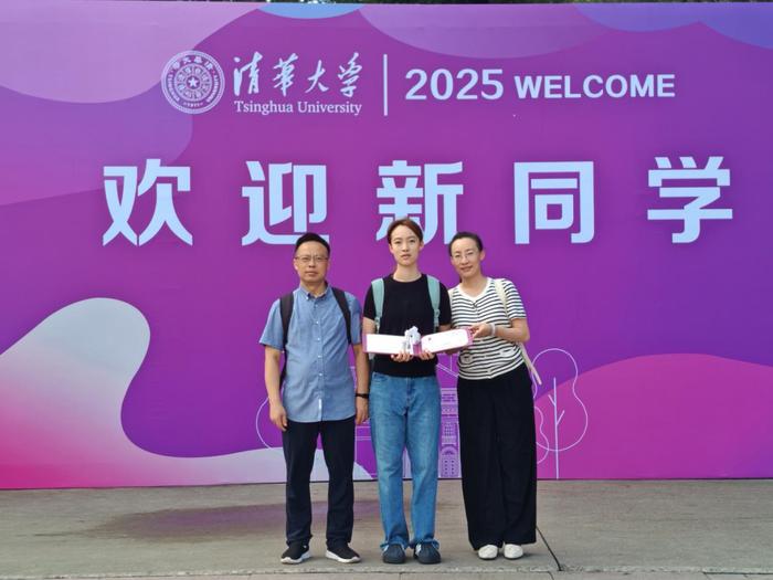 苟曾妮与父母在迎新展板前合影