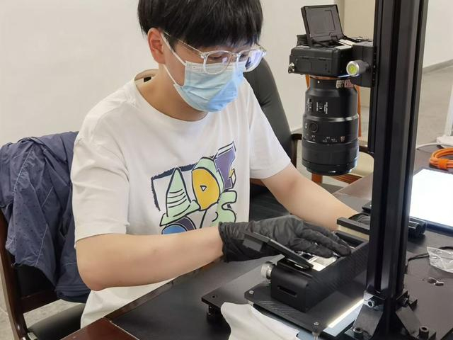 整理团队翻拍复原康正平遗存的底片。 文汇报记者 单颖文摄