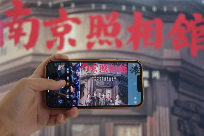 8月9日，在云南省蒙自市一电影院，观众在拍摄影片海报。新华社发（薛莹莹摄）