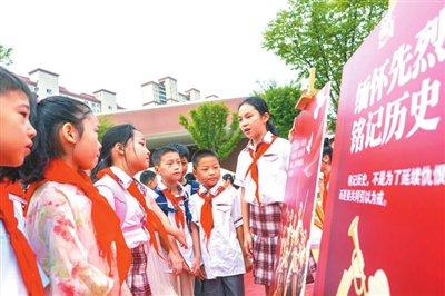 江苏省海安高新区实验小学学生在校园内参观弘扬伟大抗战精神海报展。翟慧勇摄
