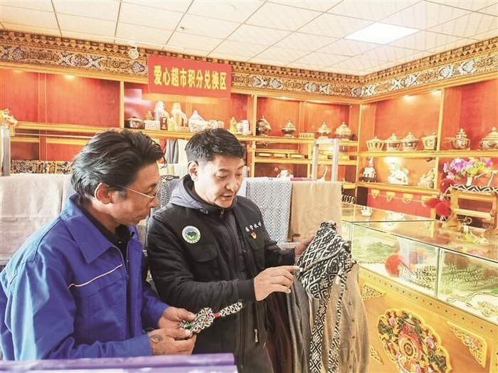 仁青才仁（右）查看公司工藝品。