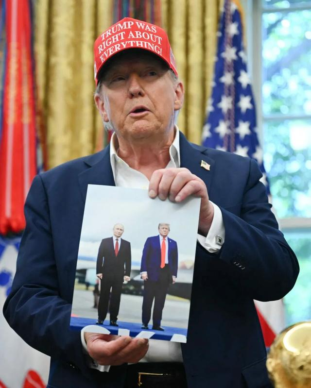 资料图片：特朗普展示他与普京合影（法新社）