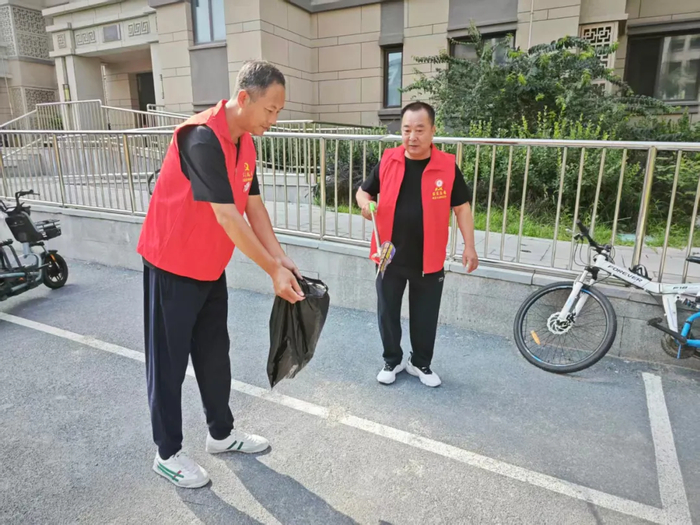 兴安社区旭日庭小区居民吴引河（左）参加志愿服务活动。