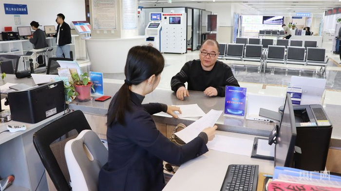 高碑店市政務(wù)服務(wù)中心工作人員協(xié)助楊先生辦理業(yè)務(wù)（央廣網(wǎng)見(jiàn)習記者 李瑤 攝）