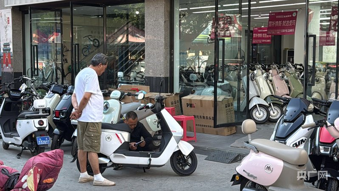 商家正為新購入電動(dòng)自行車(chē)的消費者調試車(chē)輛（央廣網(wǎng)記者 張晉鵬 攝）