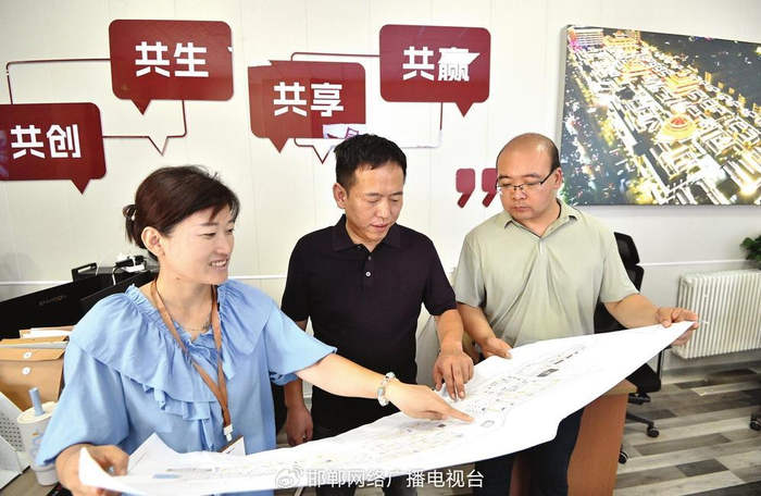 邯郸道历史文化街区招商服务中心的工作人员为商户介绍项目整体规划情况。 邯郸新闻传媒中心记者郝群英 摄